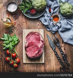 Raw fresh meat Steaks with ingredients for grilling or cooking on rustic wooden background, top view