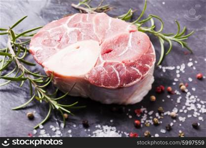 Raw fresh slice of meat - cross cut veal shank on a slate board. Cross cut veal shank