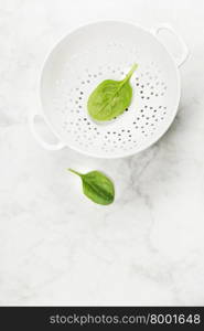 raw fresh spinach in a colander