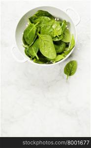 raw fresh spinach with drops in a colander
