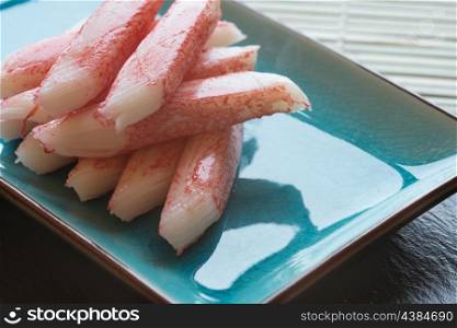 Raw fresh sushi carbsticks on plate with chopsticks