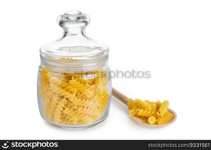 Raw fusilli in glass jar and wooden spoon with pasta isolated on white background, ingredient for cook, traditonal italian cuisine.