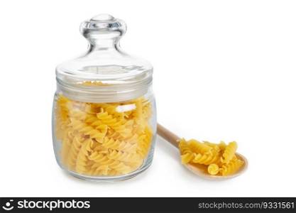 Raw fusilli in glass jar and wooden spoon with pasta isolated on white background, ingredient for cook, traditonal italian cuisine.
