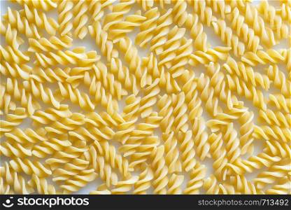 Raw fusilli pasta on the white background: top view