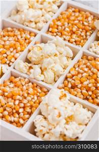 Raw golden sweet corn seeds and popcorn in white wooden box on light background.Macro