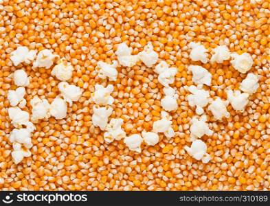 Raw golden sweet corn seeds with word POP made from popcorn