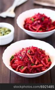 Raw grated beetroot, apple and carrot salad with parsley, photographed with natural light (Selective Focus, Focus one third into the image). Raw Grated Beetroot, Apple and Carrot Salad
