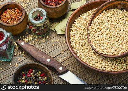 Raw green buckwheat on wooden background,vegan food. Green buckwheat on wooden table