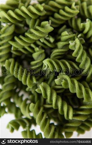 Raw green fusilli pasta, natural based on spinach and spirulina. Delicious and healthy food. Close-up. Raw green fusilli pasta, natural based on spinach and spirulina. Delicious and healthy food. Close-up.