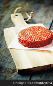 Raw Ground beef meat Burger steak cutlet on vintage wooden boards