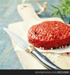 Raw Ground beef meat Burger steak cutlet with seasoning on vintage wooden boards