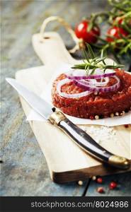 Raw Ground beef meat Burger steak cutlet with seasoning on vintage wooden boards