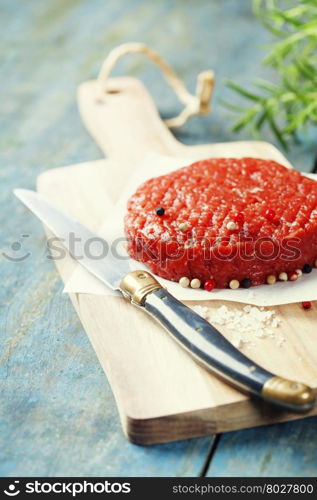 Raw Ground beef meat Burger steak cutlet with seasoning on vintage wooden boards