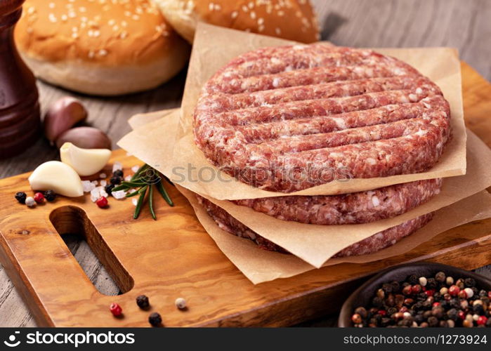 Raw Ground beef meat Burger steak cutlets on wooden background. Raw Ground beef meat