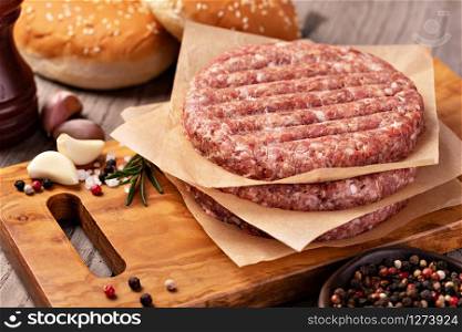 Raw Ground beef meat Burger steak cutlets on wooden background. Raw Ground beef meat