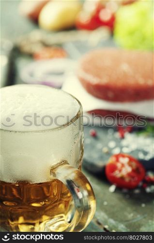 Raw Ground beef meat Burger steak cutlets with seasoning,vegetables and beer on vintage wooden boards