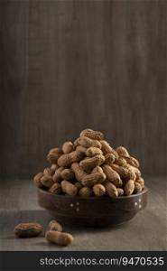 Raw groundnuts kept in a wooden bowl. 