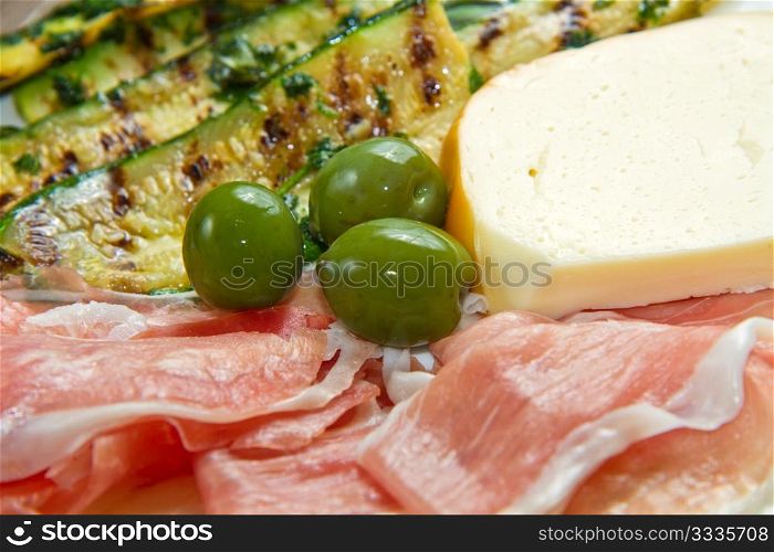 raw ham with grilled zucchini, cheese and olives