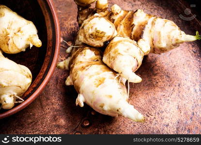 Raw Jerusalem artichokes. Harvest raw Jerusalem artichokes in in clay powder