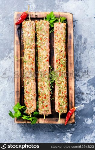 Raw kebabs in skewers. Caucasian popular dish, kebab from young lamb meat and spices.Flat lay