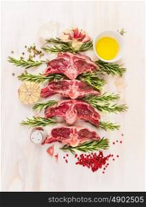 Raw lamb chop cutlet with oil , rosemary and garlic on white wooden background, top view