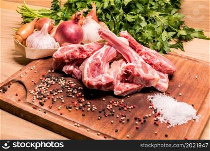 raw lamb chops on a wooden board for barbecue