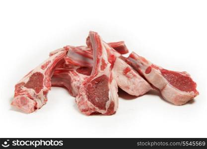 Raw lamb chops piled in a heap against a white background.
