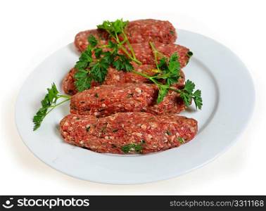 Raw lamb kofta, a favourite Arabian grill or barbecue treat, on a white plate.