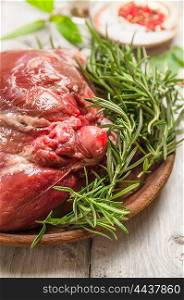 Raw leg of lamb , preparation on rustic wooden background