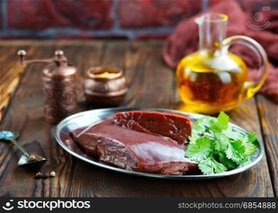 raw liver on plate and on a table