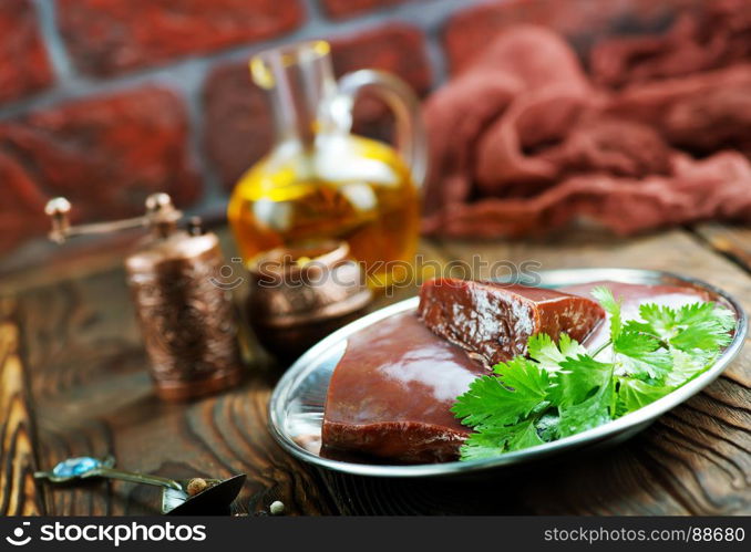 raw liver on plate and on a table