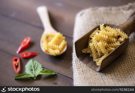 Raw macaroni on wooden background