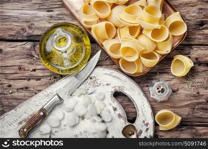 Raw macaroni on wooden background. macaroni with ingredients for cooking pasta on wooden table