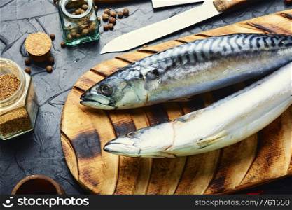 Raw mackerel fish and spices on the kitchen table. Seafood. Fresh, raw mackerel fish