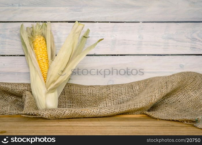 Raw maize cob on a wooden table