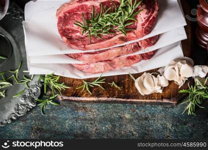 Raw marbled meat steaks , preparation with herbs and spices, top view, border