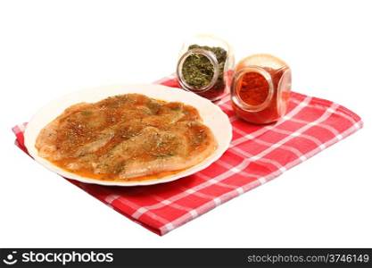 Raw marinated chicken breasts with spices and herbs on white background