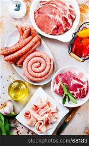 raw meat and raw sausages on the wooden board