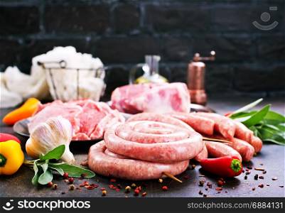 raw meat and sausages on a table, stock photo
