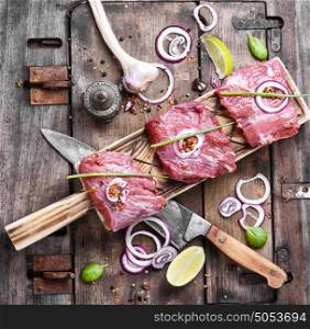 Raw meat beef steak. Raw beef meat on cutting board with spices and onion