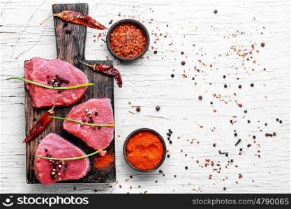 Raw meat beef. Three raw chops veal steak with peppers and spices