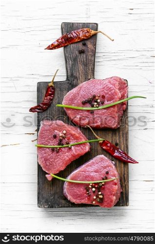 Raw meat beef. Three raw veal steak with peppers and spices