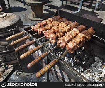 Raw meat is prepared on skewers grilled barbecue on charcoal. Grill on charcoal and flame, picnic, street food.. Raw meat is prepared on skewers grilled barbecue on charcoal