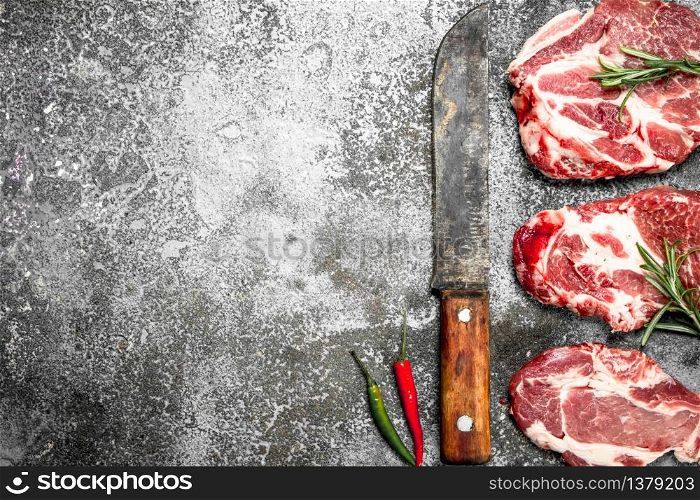 Raw meat of beef with rosemary and hot peppers. On rustic background.. Raw meat of beef with rosemary and hot peppers.