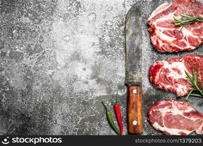 Raw meat of beef with rosemary and hot peppers. On rustic background.. Raw meat of beef with rosemary and hot peppers.