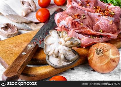 Raw meat on cutting board. raw meat selection and mushroom on wooden cutting board with knife