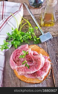 raw meat on the wooden board and on a table