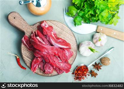 raw meat on wooden board and on a table