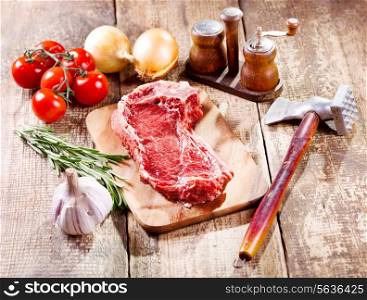 raw meat with fresh vegetables on wooden table