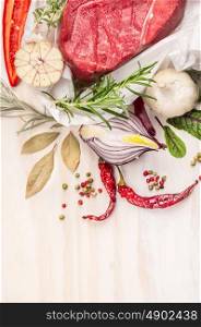 Raw meat with herbs and spices: bay leaf, garlic, pepper on white wooden background, top view, close up, place for text